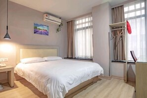 A bedroom with a bed, bedside table, and a window with curtains. - Ruide Te Hotel (Hangzhou Xiaoshan Renmin Road Subway Station) (Hangzhou)