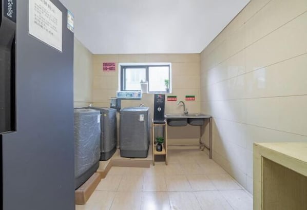 A compact kitchen with a window, a sink, and a refrigerator. - Ruide Te Hotel (Hangzhou Xiaoshan Renmin Road Subway Station) (Hangzhou)