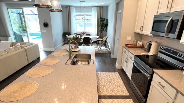 A modern kitchen with a central island, stainless steel appliances, and pendant lighting.