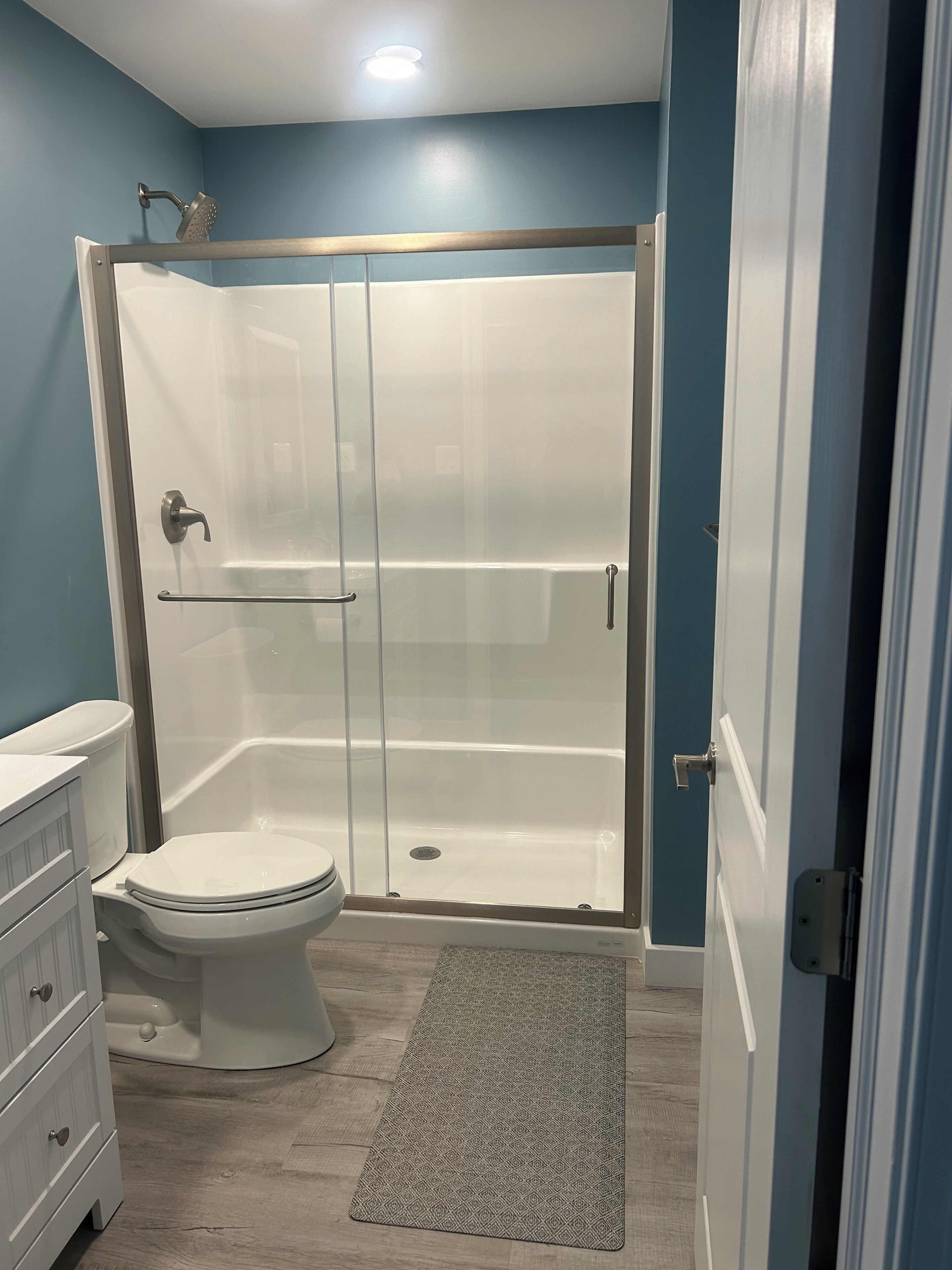 A bathroom with a shower, toilet, and vanity.
