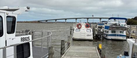A wooden dock with boats moored at the end.