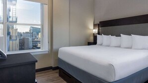 A hotel room with a large bed, a desk, and a window with a city view. - Super8 hotelroom, in the heart of San Francisco for your RSAC or Dreamforce stay (San Francisco)