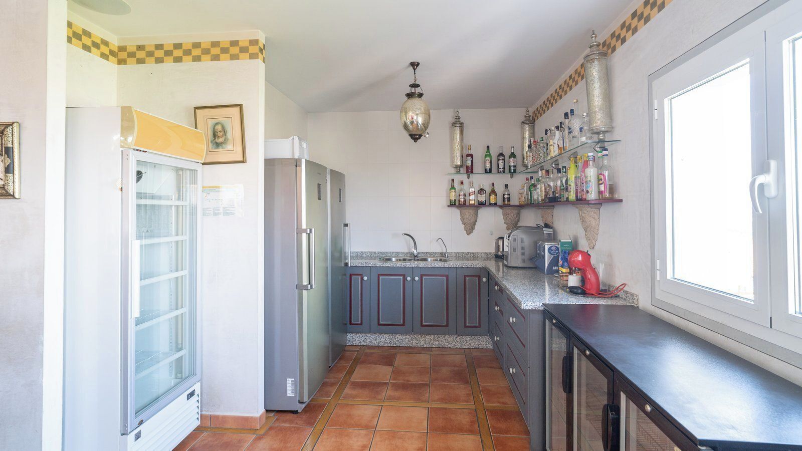 Une cuisine équipée d’un réfrigérateur, d’un évier, d’une cuisinière et d’une fenêtre.