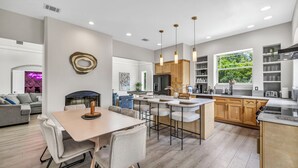 Una cocina moderna con armarios de madera, una isla central e iluminación colgante.