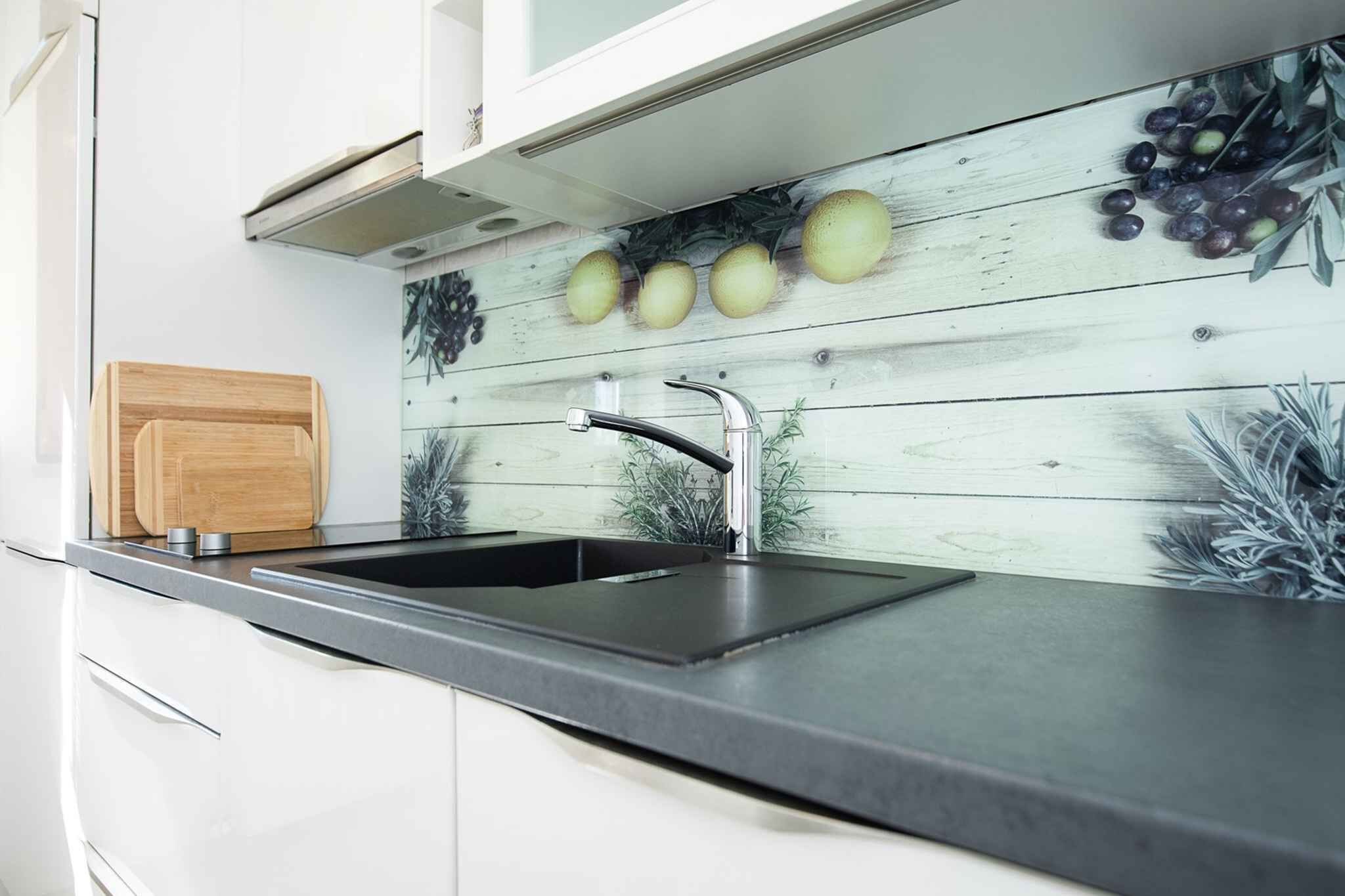 Eine moderne Küche mit einem schwarzen Spülbecken, weißen Schränken und einer Holzschneidebrett.
