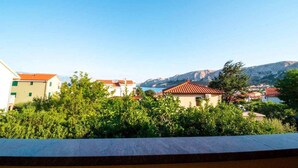 A residential area with houses, greenery, and a mountainous backdrop. - Holiday apartment mit Balkon (Baška)