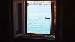 A window with a view of a calm sea and a small boat. - Holiday apartment near the sea (Baška)