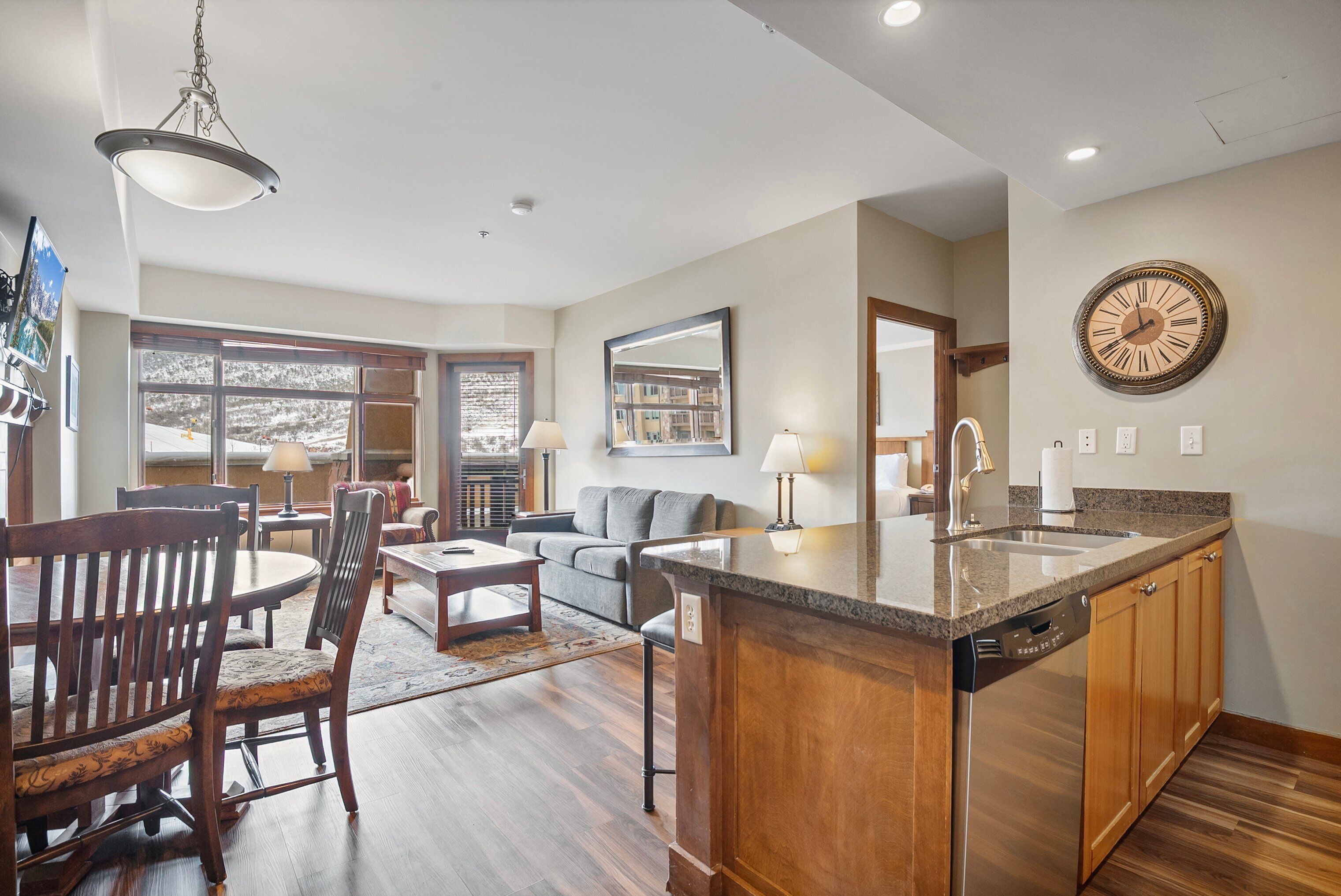 A modern kitchen with a central island, wooden cabinets, and a built-in dishwasher.