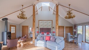 Ein großzügiges Loft mit hoher Decke, Kamin, einer großen Couch und einem Essbereich.