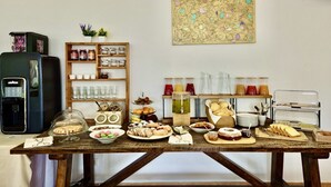 Ein Frühstücksbuffet mit verschiedenen Speisen, einer Kaffeemaschine und einem dekorativen Wandbild.