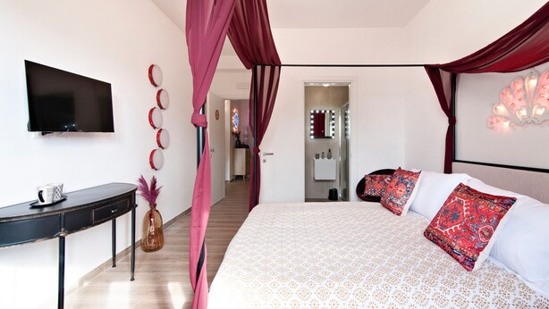 A bedroom with a large bed, a TV, a desk, and a mirror. - 7Rooms - The Party - Lecce Selection (Lecce)