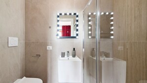 A modern bathroom with a glass shower enclosure, a white sink with a mirror above it, and a toilet. - 7Rooms - The Party - Lecce Selection (Lecce)