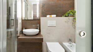 A modern bathroom with a glass shower enclosure, a white sink, a bidet, and a large mirror. - Kalurya - Baroque - Lecce Selection (Lecce)