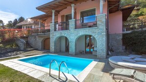 A two-story house with a swimming pool, stone arches, and a balcony with outdoor furniture. - Villa Rosalia - MyHomeinComo (Menaggio)