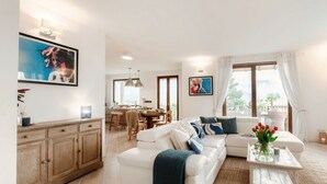 Ein modernes Wohnzimmer mit einer Couch, einem Couchtisch und Kunstwerken an den Wänden.