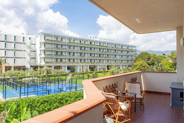 Un hotel con piscina, mobiliario exterior y vistas del paisaje circundante.
