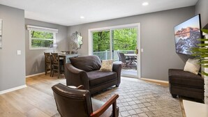 Un salon spacieux doté d’une grande fenêtre, d’un coin repas et d’un espace salon confortable.