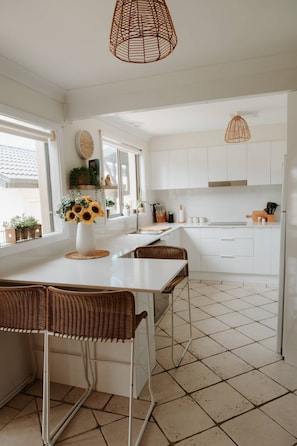 Enjoy meals in this kitchen with a central island, sink, and large window offering a view of the outdoors.