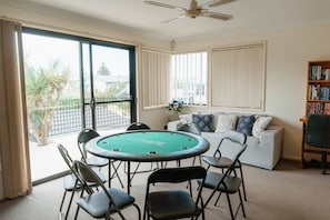 Relax in this stylish room with a large pool table, comfortable seating, and a bookshelf filled with books.