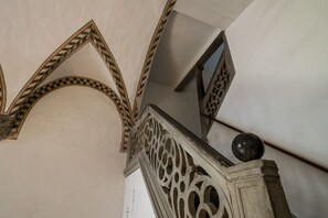 Een architectonisch detail met een geometrisch patroon op de muur en een balustrade met een bolvormige bekroning.