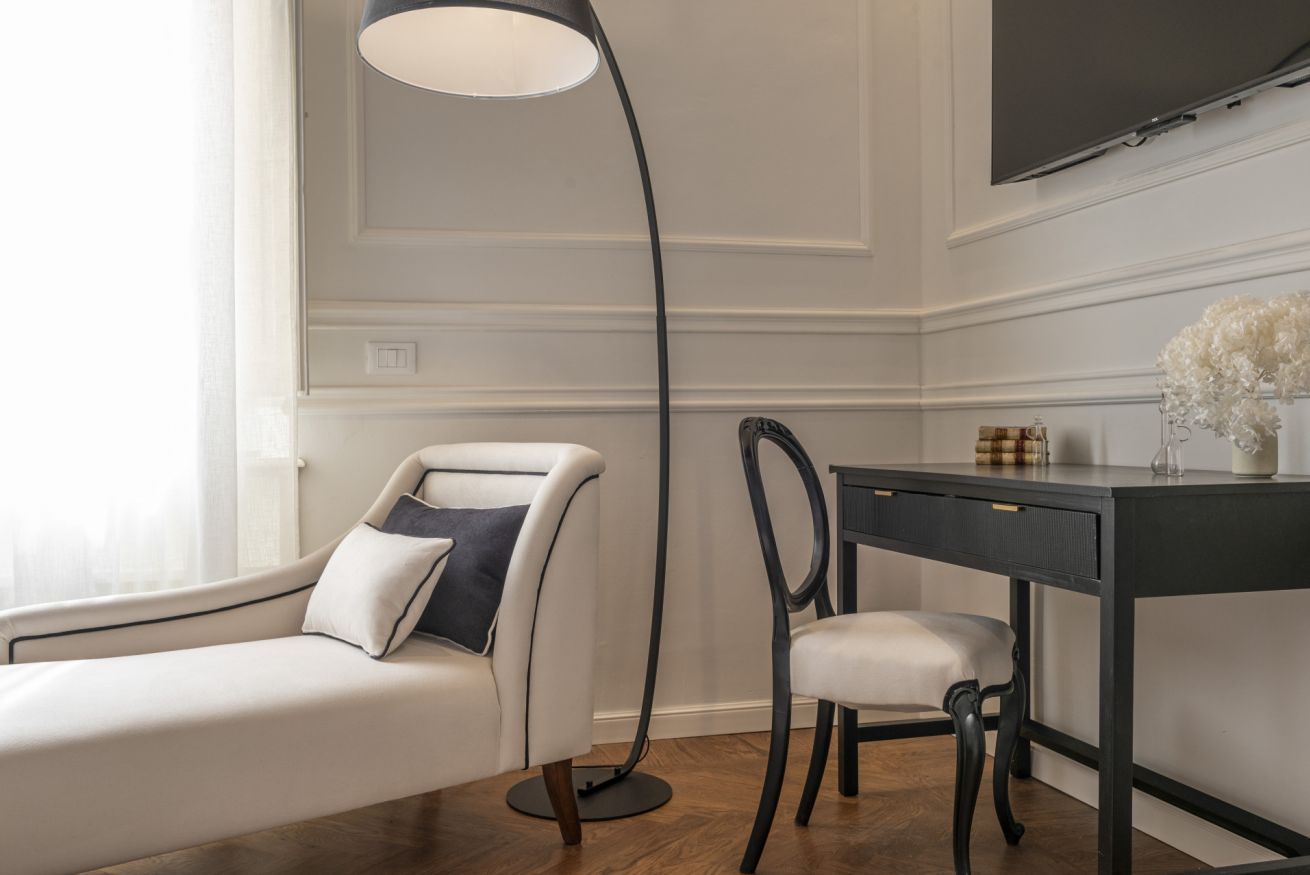 Une chambre moderne avec un canapé, un bureau et une lampe sur pied.