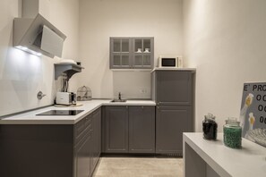 Une cuisine moderne avec des meubles de couleur grise, un four à micro-ondes, un grille-pain et un évier.