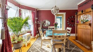 A dining room with a wooden table, chairs, a chandelier, and a large mirror on the wall. - Large Space Great for Special Occasions: 2 Floors (Montclair)
