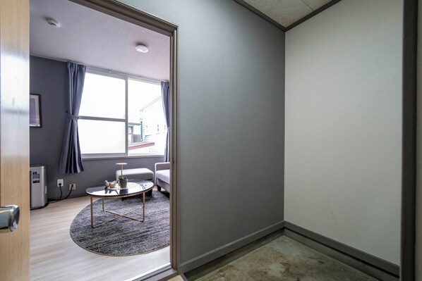 A modern room with a round coffee table, a sofa, and a small table with a plant. - VITA (Furano)
