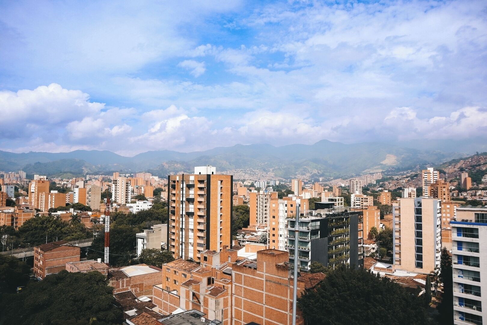 A cityscape with numerous high-rise buildings, some with visible balconies and terraces.