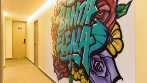 A hallway with a colorful graffiti mural on the wall, a door labeled "402", and a light fixture on the ceiling. - Stadio Serenity Rosa Negra Aparta-suite (Medellín)