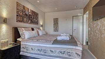 Een hotelkamer met een groot bed, een tv aan de muur en een schilderij van fietsen.