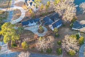 Vue aérienne d’un quartier résidentiel avec de nombreuses maisons, une allée sinueuse et des arbres environnants.