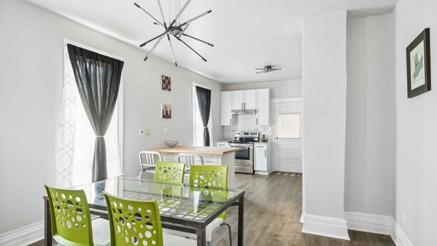 A modern kitchen with white cabinets, a central island, and a ceiling fan. - Downtown Detroit Gem 3 Bedrooms & Culture! (Detroit)