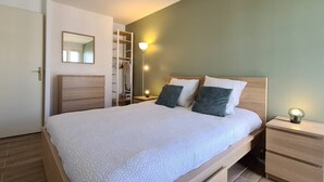 A bedroom with a bed, nightstands, a wardrobe, and a mirror. - Appt 80m², 13 P,  Disneyland, Fibre, 2 parkings (Chessy)