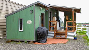 Cozy retreat with a covered porch, door, and windows, perfect for relaxation.
