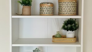 A white shelving unit with decorative items including a wooden sign reading "NAMASTE," a potted plant, patterned containers, and a tray with a glass jar. - Gd 4P 85m² hyper centre Disney (Chessy)