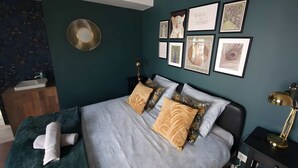 A bedroom with a bed, a bedside table, a lamp, and a wall with framed pictures. - Gd 4P 85m² hyper centre Disney (Chessy)