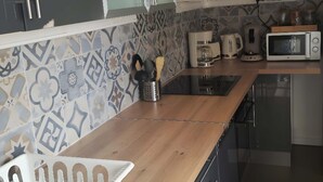 A modern kitchen with a wooden countertop, stainless steel appliances, and patterned backsplash. - Gd 4P 85m² hyper centre Disney (Chessy)