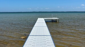 A long, narrow pier extending into calm water under a clear blue sky. - Luxury Waterfront Home in Suttons Bay (Suttons Bay)