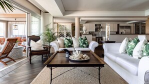 Un vaste espace de vie comprenant un canapé blanc, des chaises en bois et une table basse.