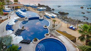 A resort with a large infinity pool, beachside lounge chairs, and a view of the ocean. - 3-bedroom resort in wonderful Cabo San Lucas with WiFi, fitness room (Cabo San Lucas)
