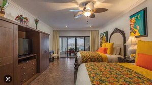A hotel room with a bed, a television, a ceiling fan, and a view of the outdoors. - 3-bedroom resort in wonderful Cabo San Lucas with WiFi, fitness room (Cabo San Lucas)