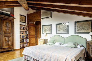 Un dormitorio con una cama grande, estanterías de madera y cuadros en la pared.