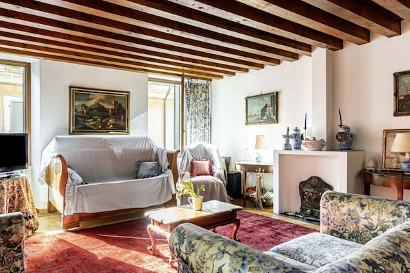 Una sala de estar con sofá, sillones, una mesa de centro y chimenea.