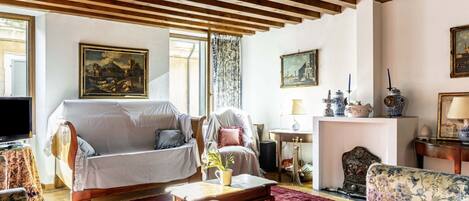Una sala de estar con sofá, sillones, una mesa de centro y chimenea.