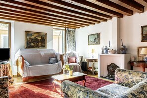 A living room with a sofa, armchairs, a coffee table, and a fireplace. - GuestHost - Large apartment with an ancient and romantic flavor of 198 sqm, ideal for 5 people, located on three floors of a renovated period building from 1990 with a lift (stairs to access it). The accommodation is located in the historic center and en (Verona)