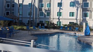 A hotel pool area with lounge chairs and a thatched umbrella. -  hotel suite with WiFi, fitness room in brilliant Orlando (Orlando)