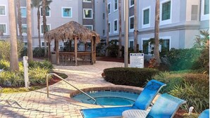 A hotel pool area with a hot tub, lounge chairs, and a gazebo. -  hotel suite with WiFi, fitness room in brilliant Orlando (Orlando)