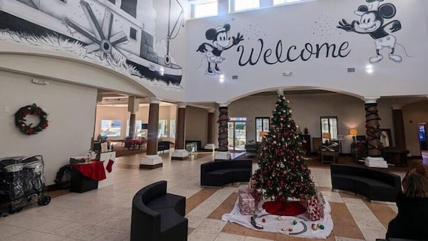 A spacious lobby with a large welcome sign, a Christmas tree, and a mural of Mickey Mouse. -  hotel suite with WiFi, fitness room in brilliant Orlando (Orlando)