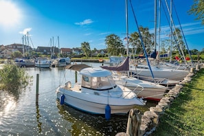 A marina with boats docked along a grassy embankment.